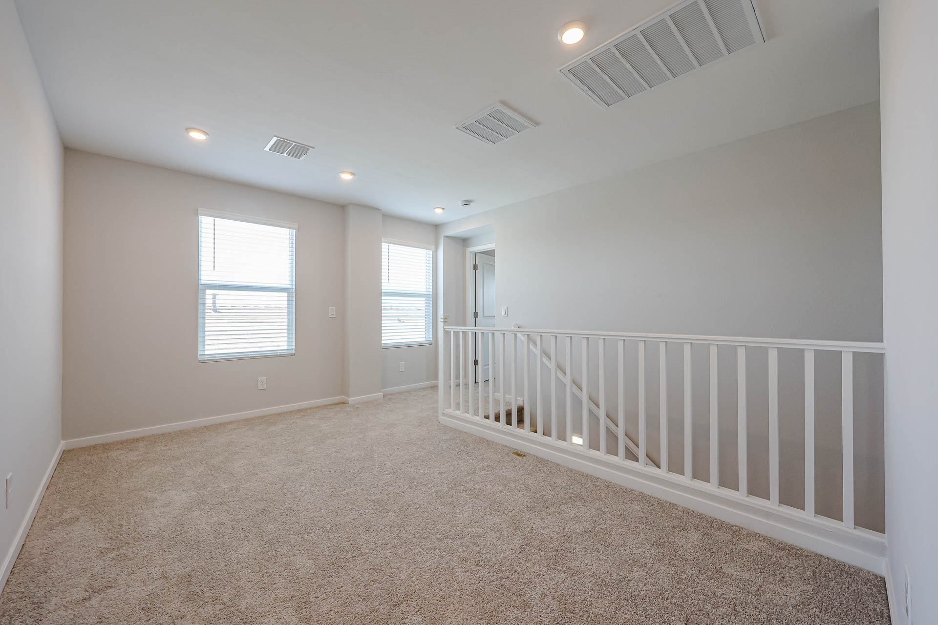 A room with a white railing and a white railing.