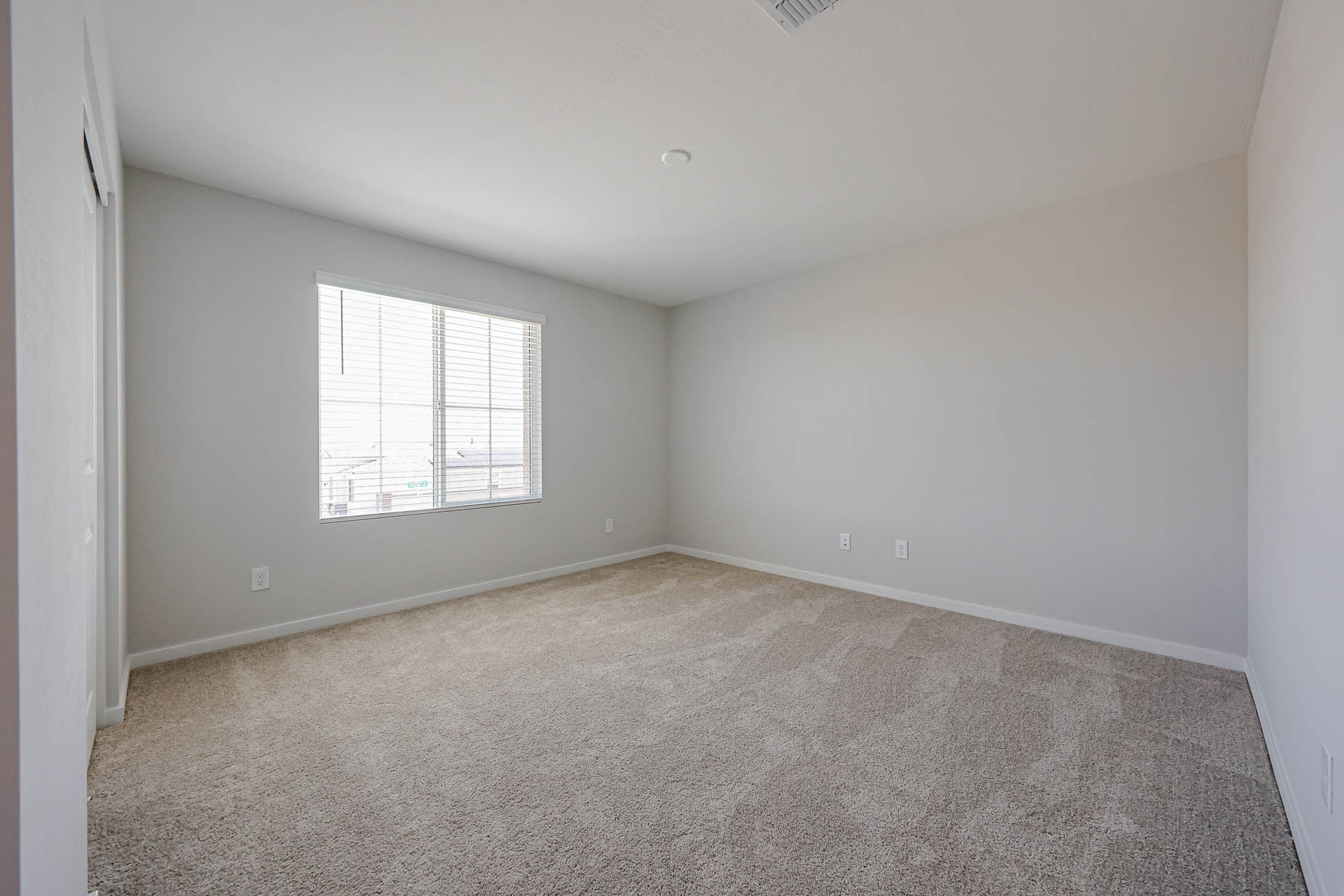 A room with a window and a carpet.