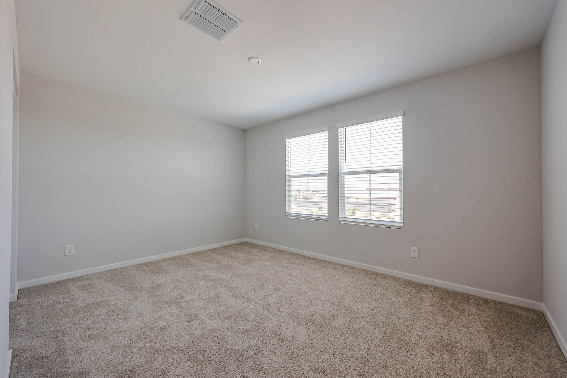 A room with a carpet and windows.
