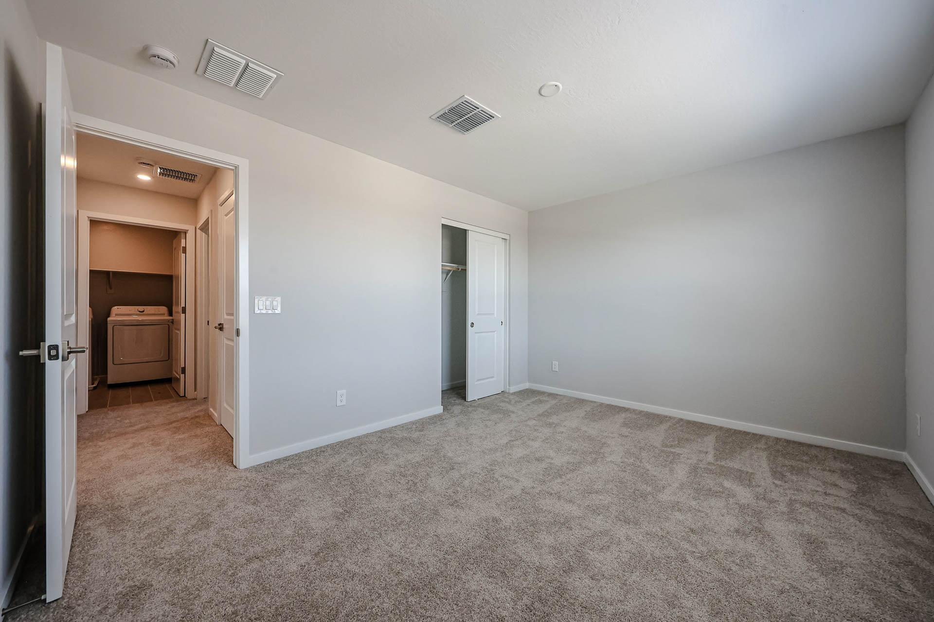 A room with a carpet and doors.