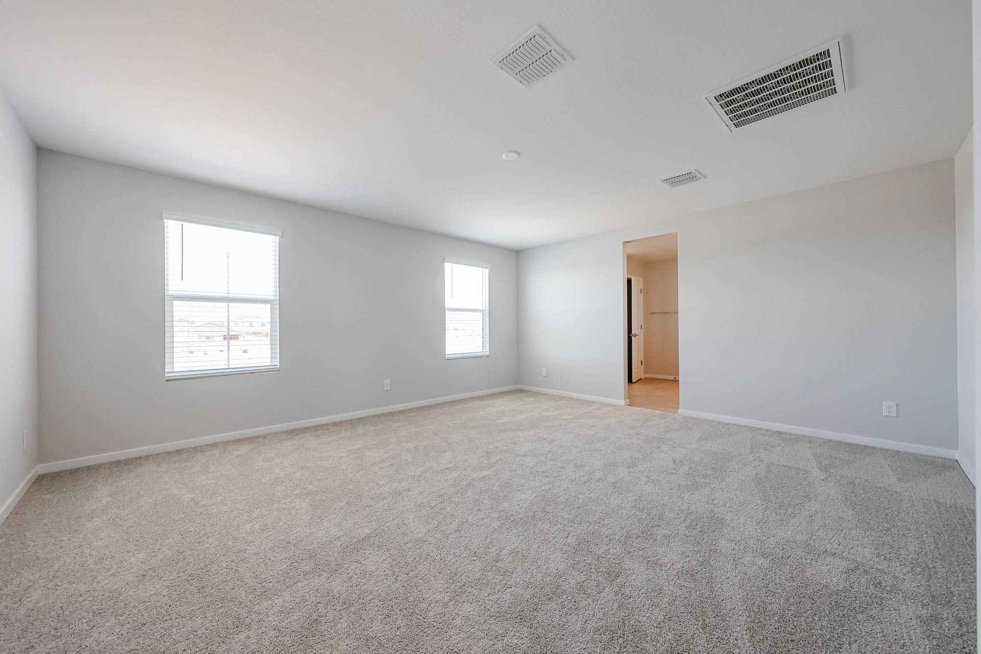 A room with a carpet and a door.