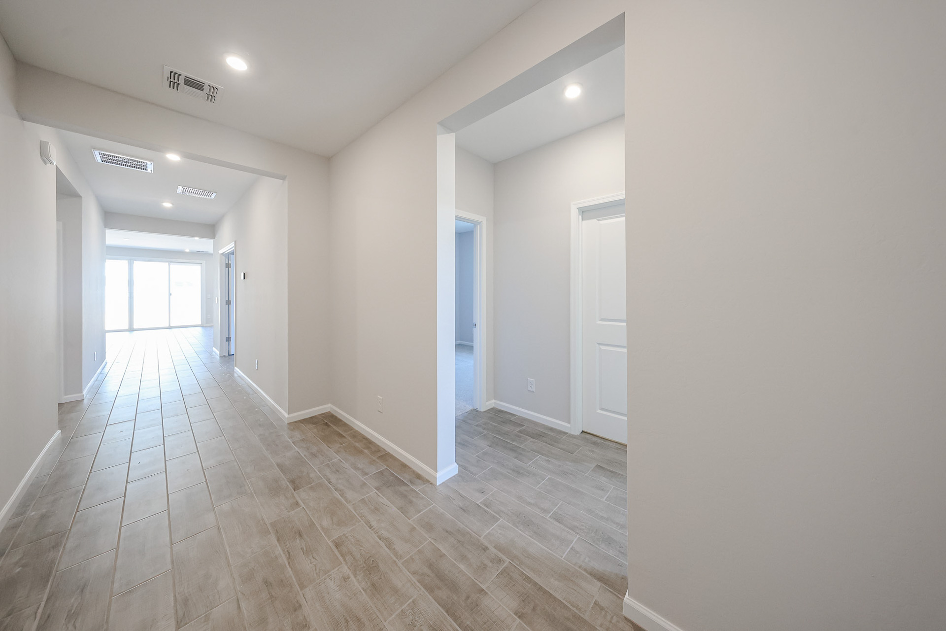A long hallway with white doors.