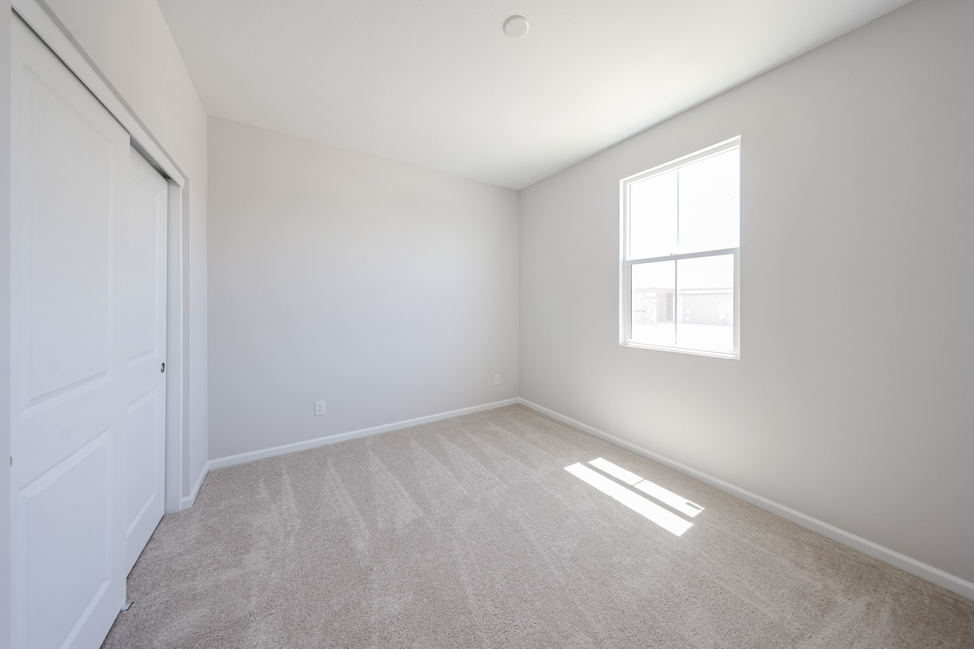 A room with white walls and a window.