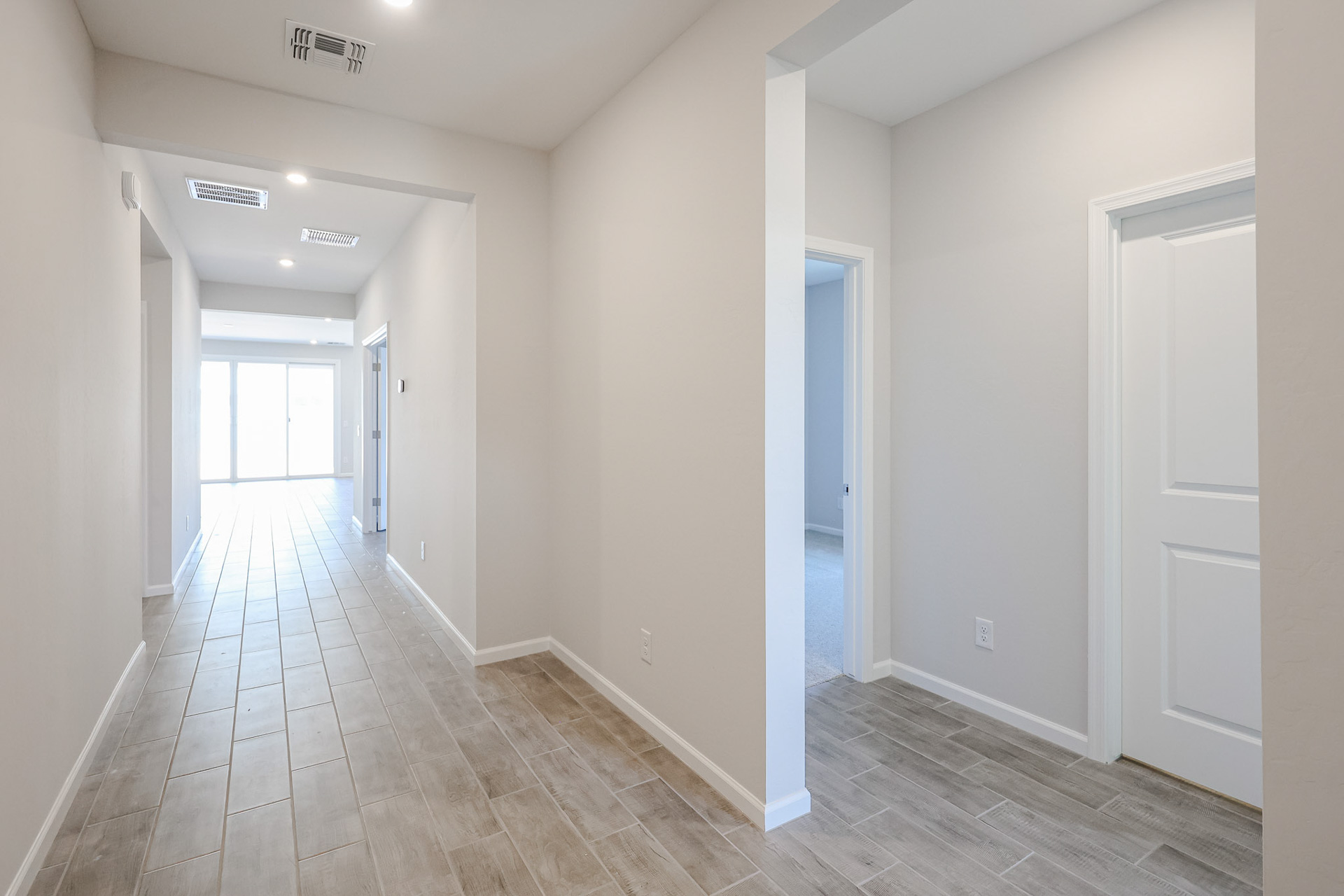 A long hallway with white doors.