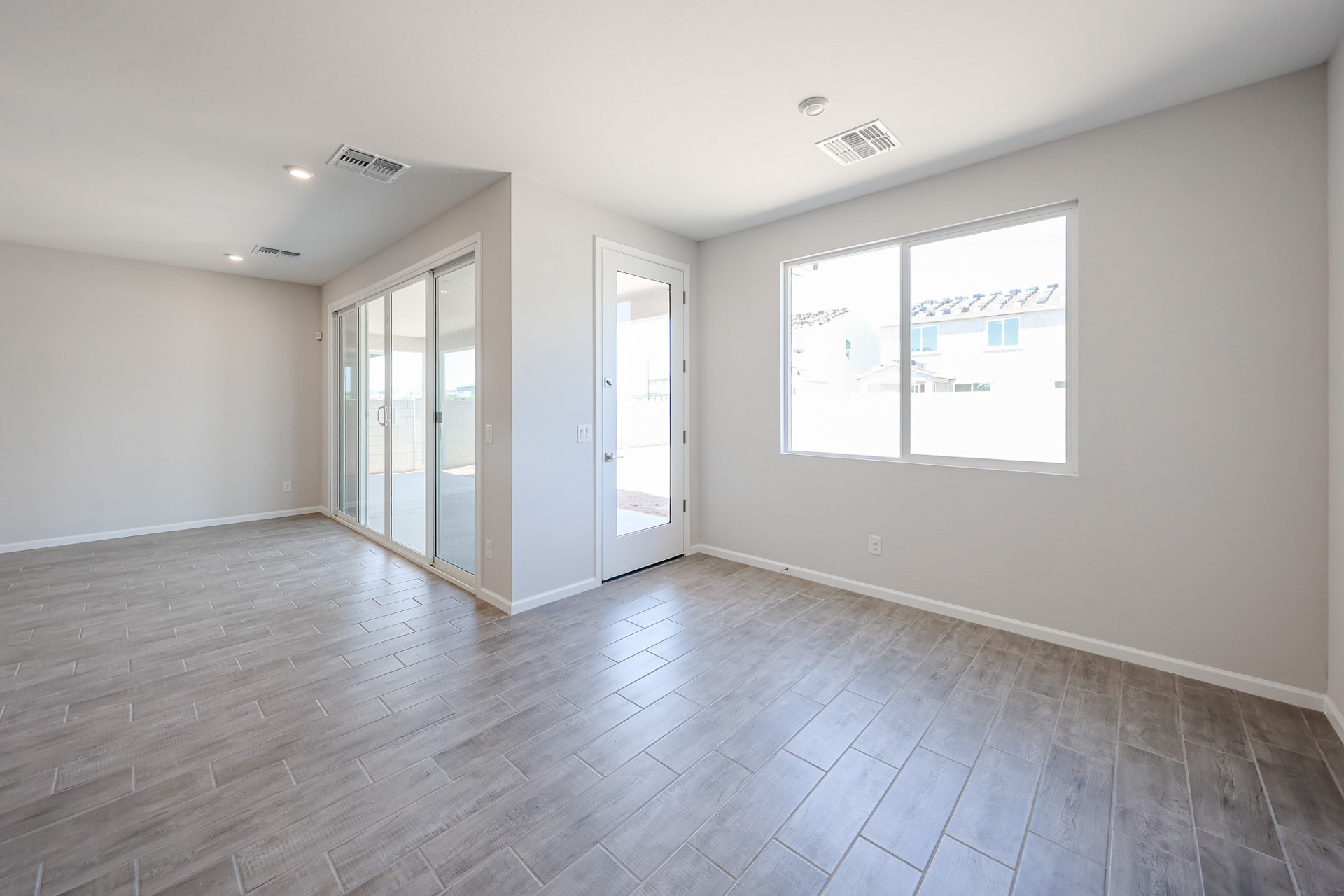 A room with a wood floor and a window with a door.