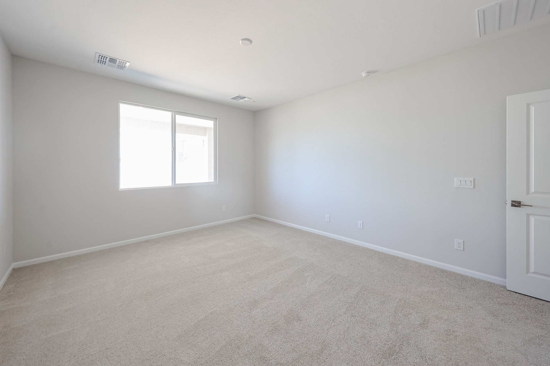 A room with a carpet and a window.