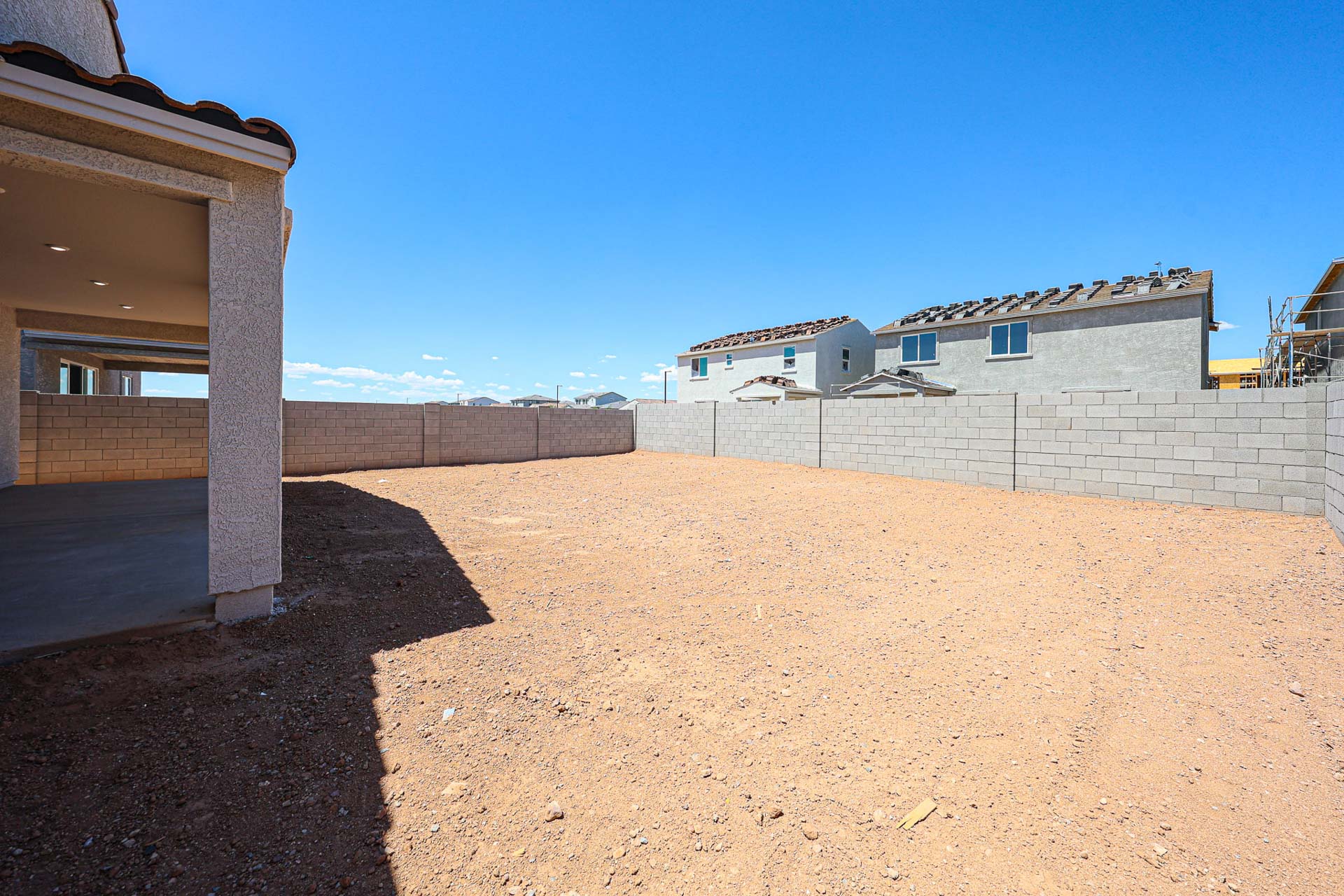 A dirt area with buildings in the background.
