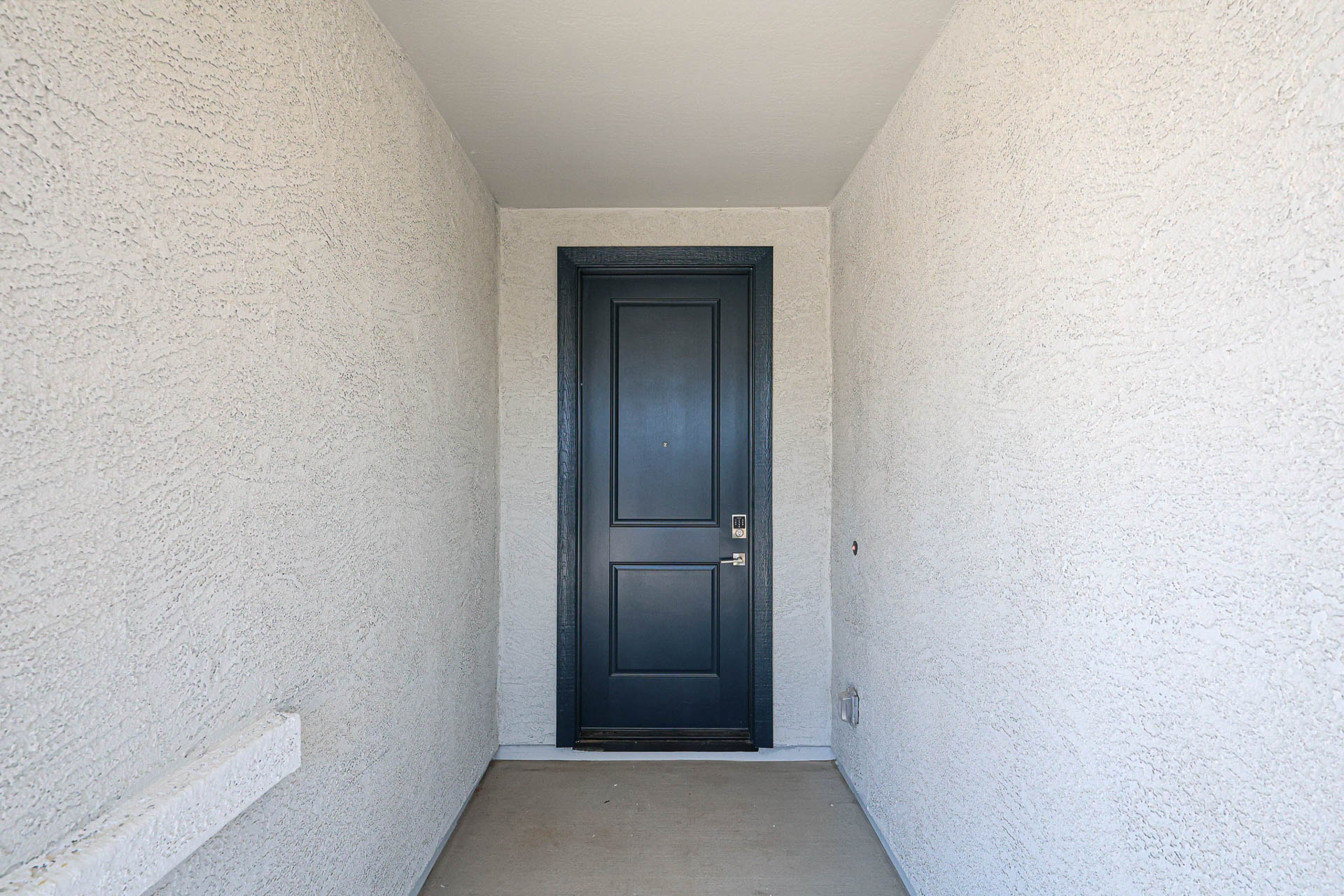 A black door in a white room.