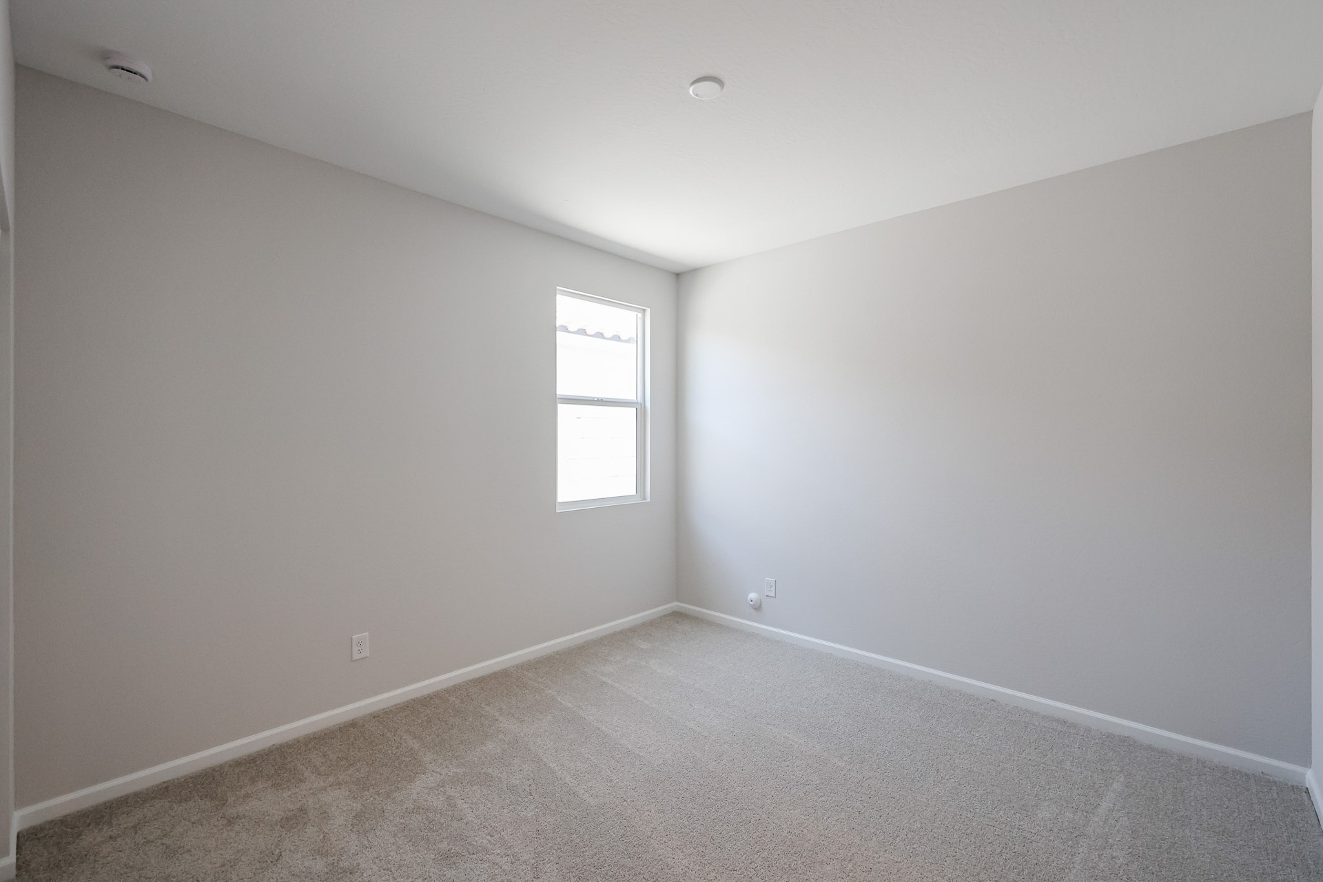 A room with a window and a carpet.