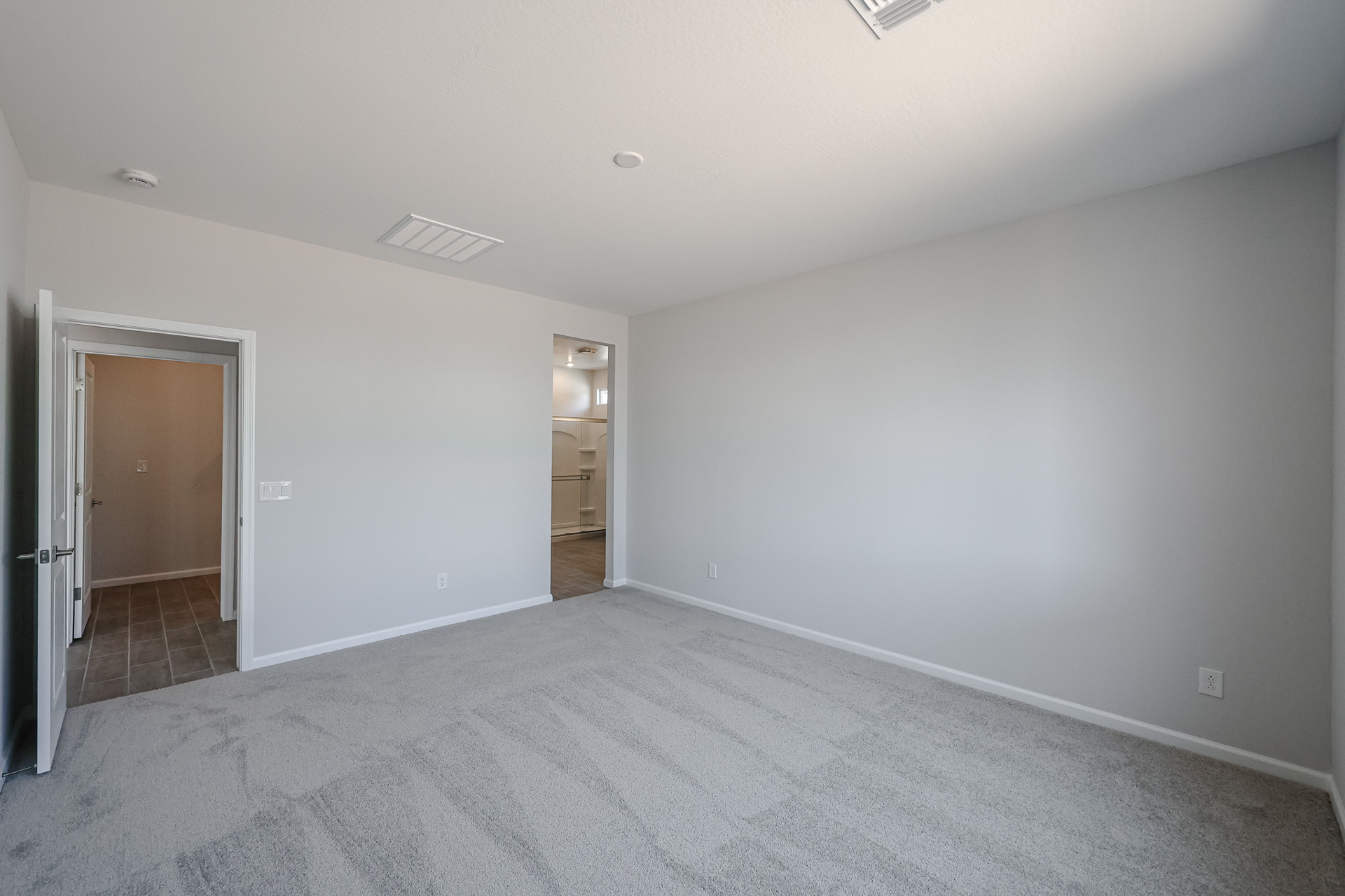 A room with a carpet and a door.