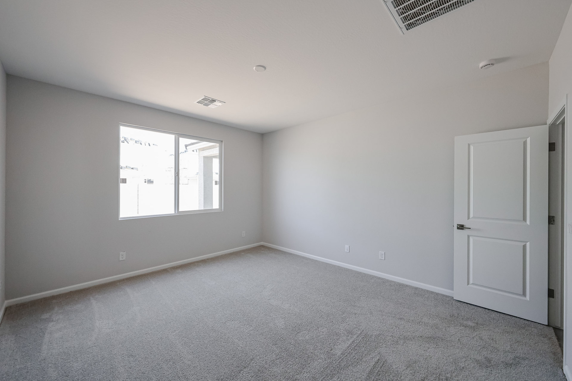 A room with a white door and a window.