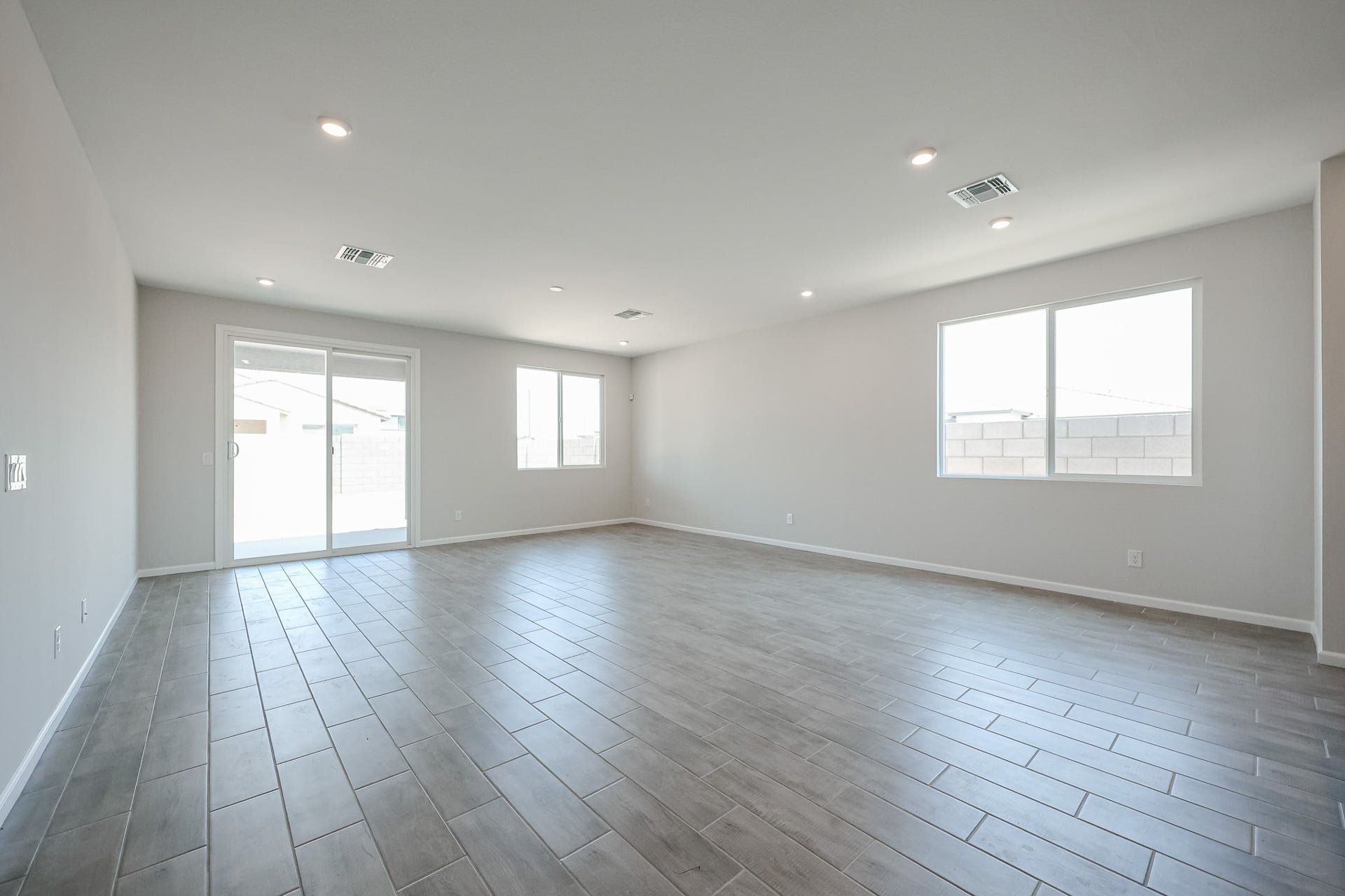 A room with windows and a wood floor.