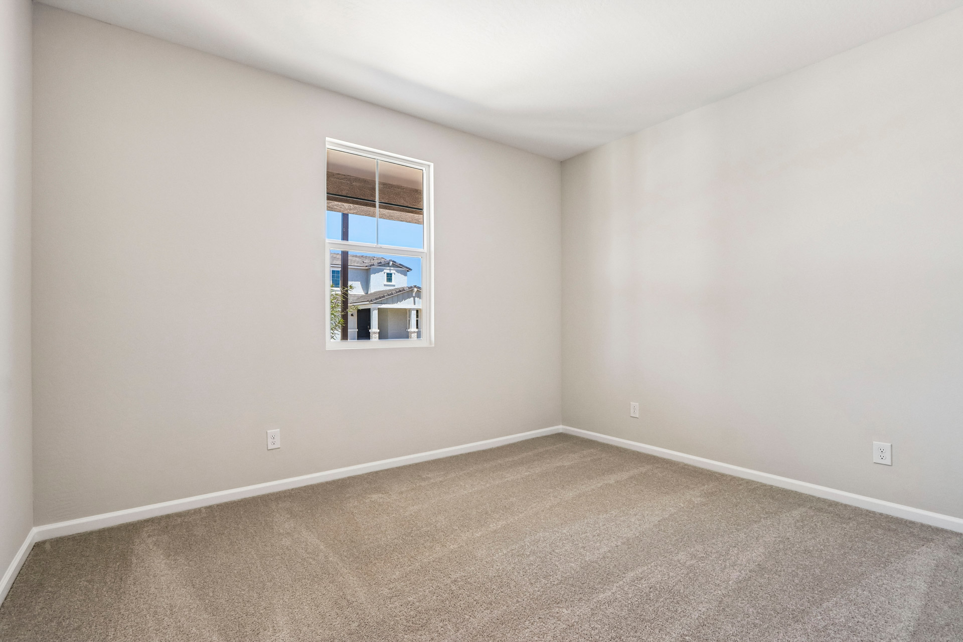 A room with a window and a carpet.