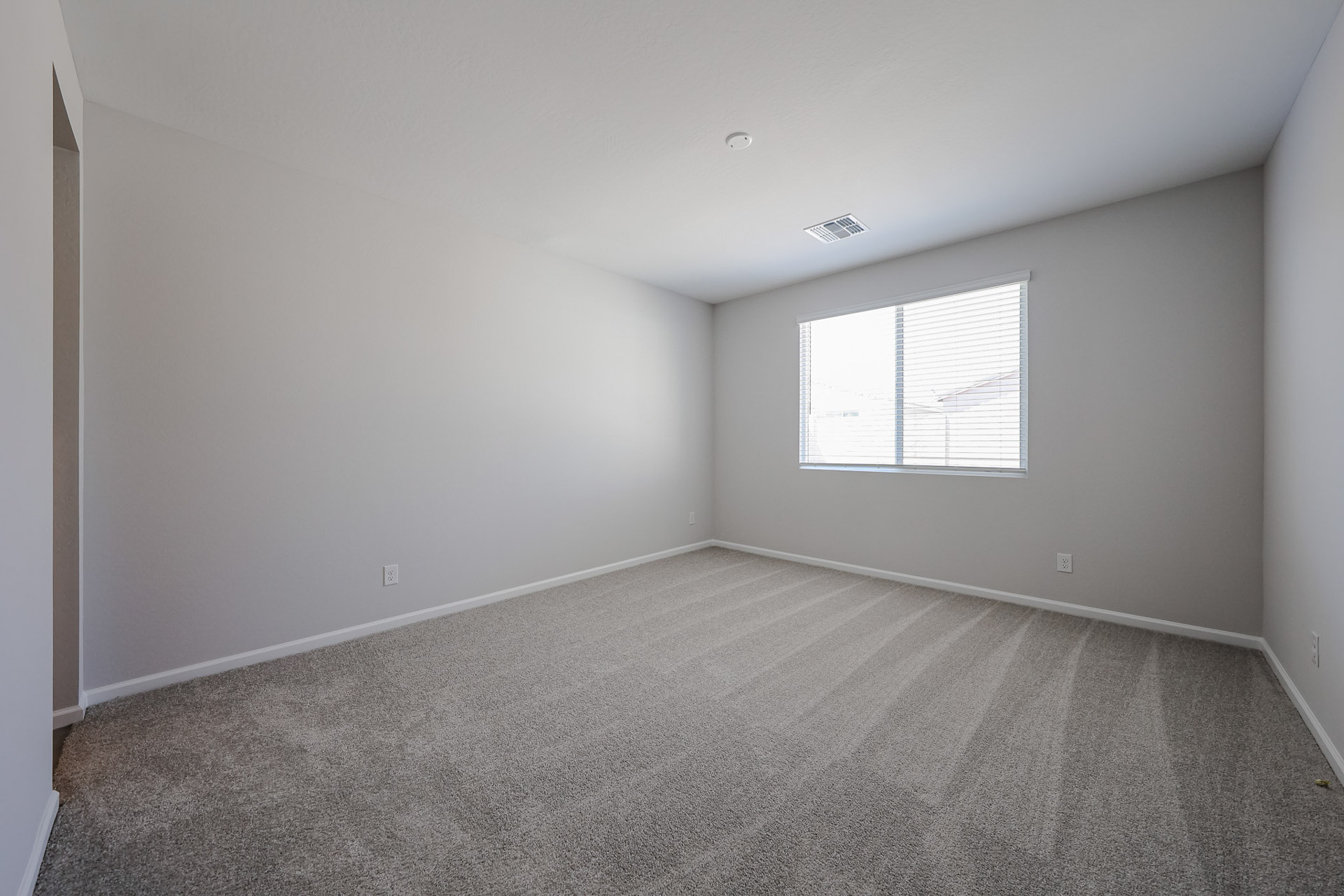 A room with a carpet and windows.