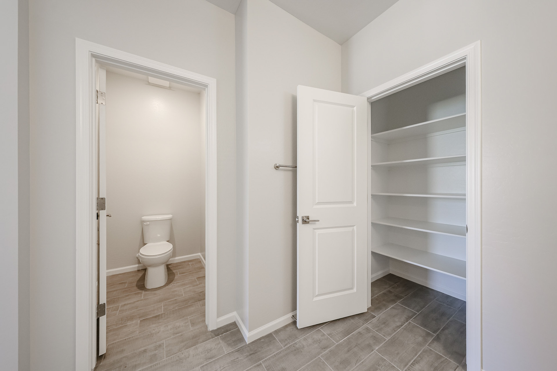 A bathroom with a toilet and a shelf.