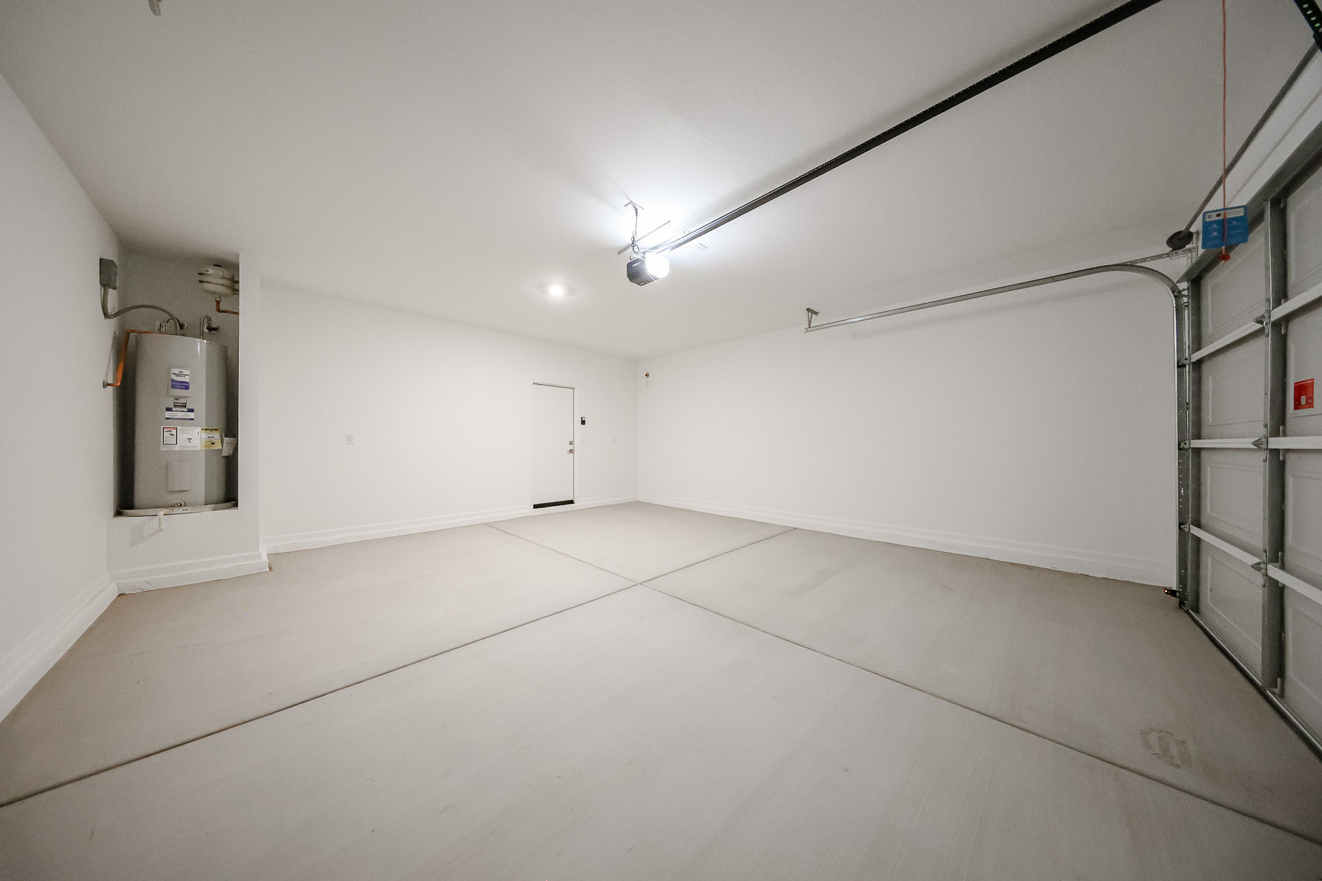 A room with a white wall and a metal box.