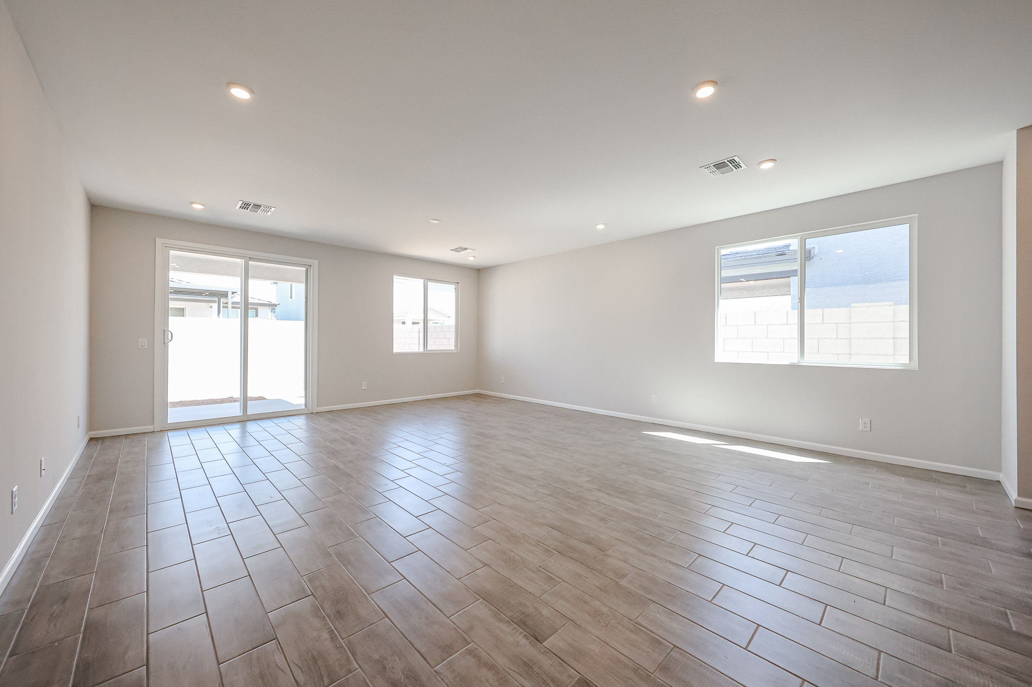 A room with a wood floor and windows.