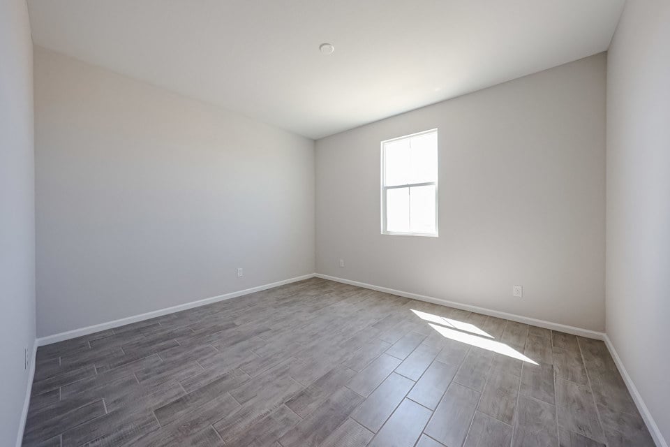 A room with a wood floor and windows.
