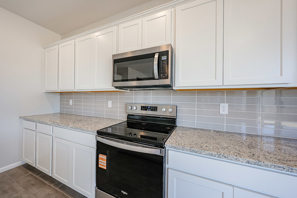 A kitchen with white cabinets.