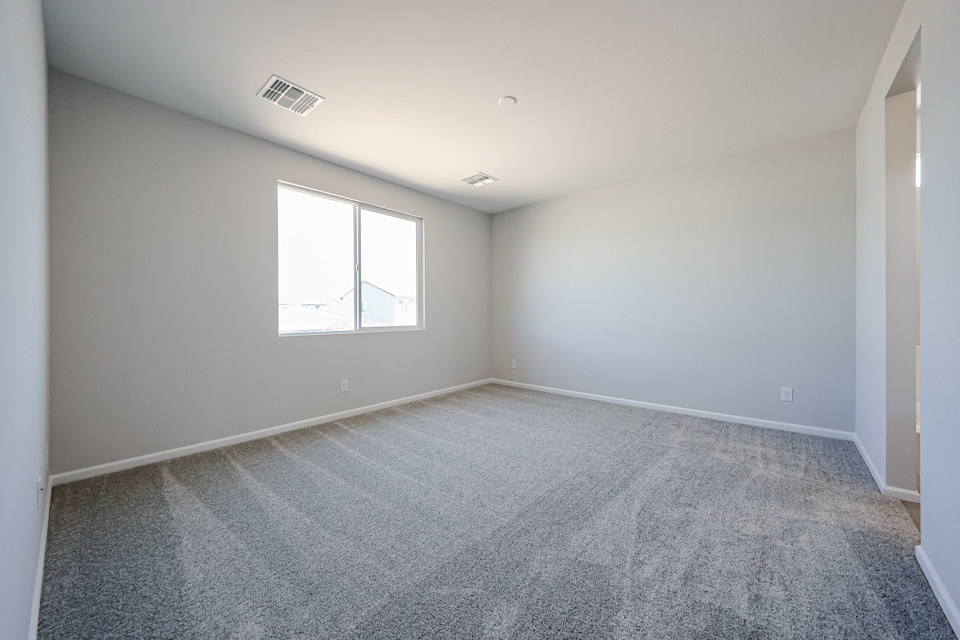 A room with a carpet and windows.