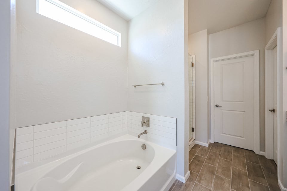 A bathroom with a tub and toilet.