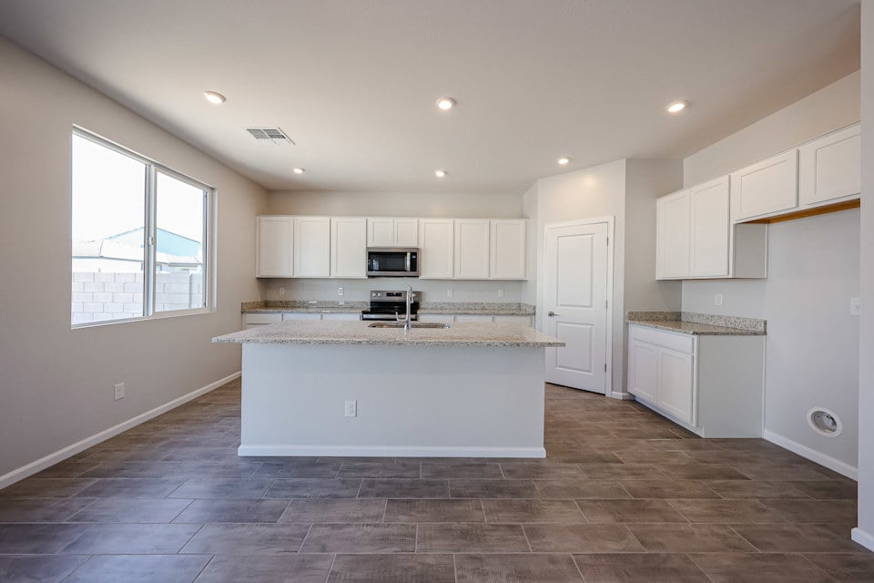 A kitchen with white cabinets.