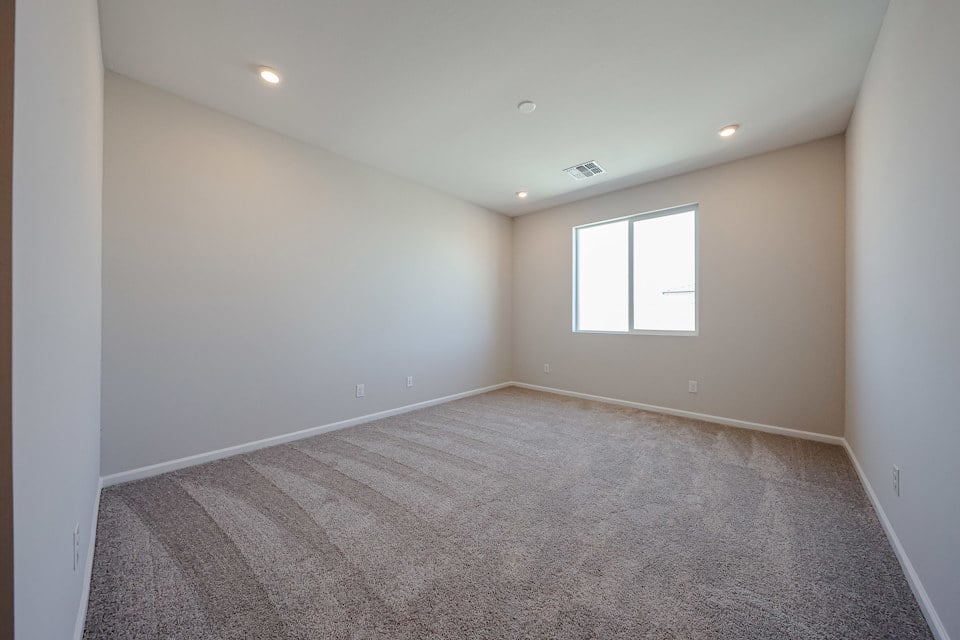 A room with a carpet and windows.