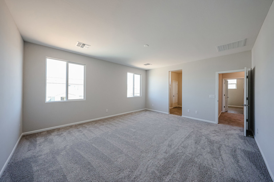 A room with a carpet and windows.