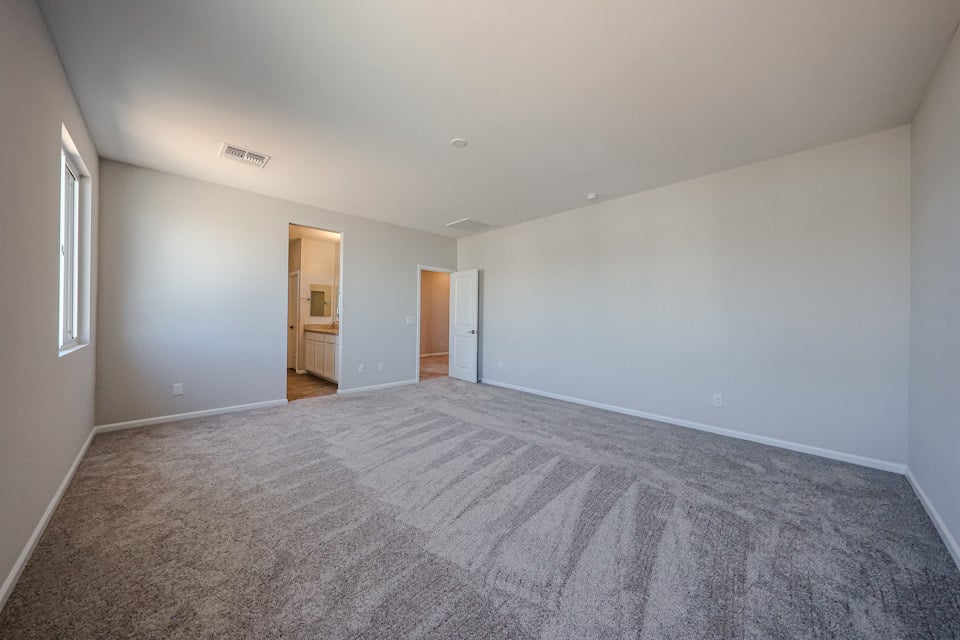 A room with a carpet and a door.