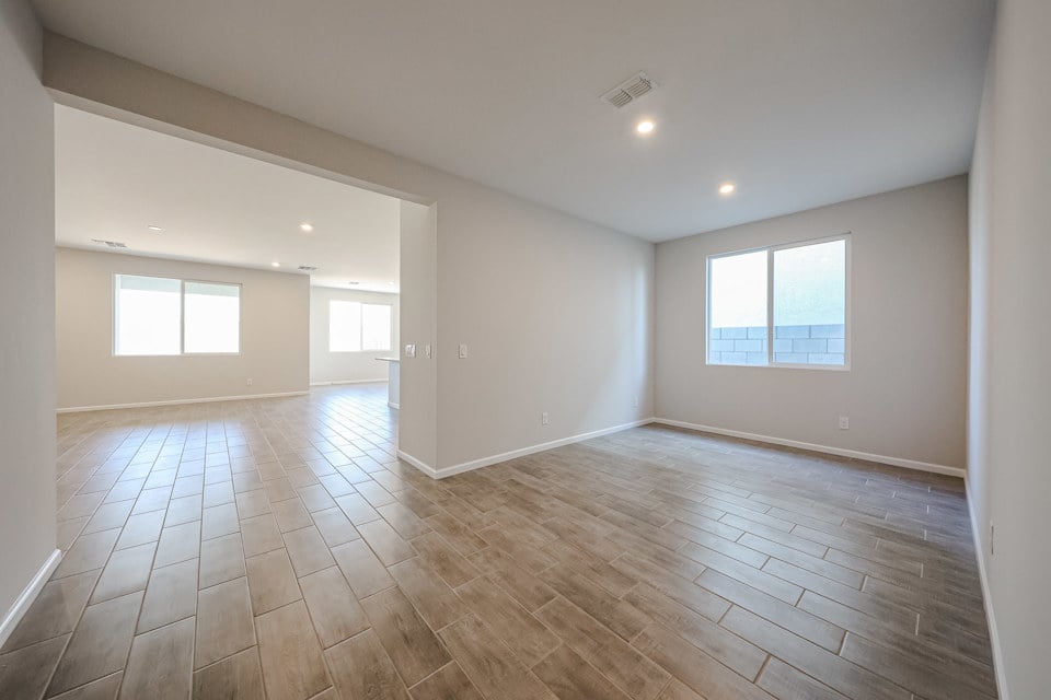 A room with a wood floor and windows.
