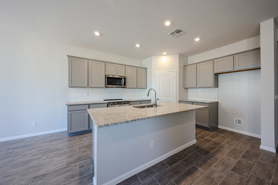 A kitchen with white cabinets.