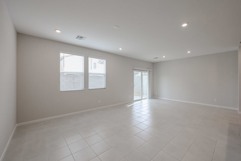 A room with white tile floor and windows.