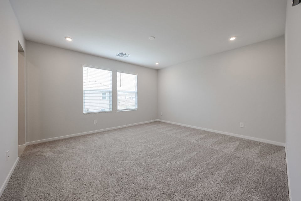 A room with a carpet and windows.