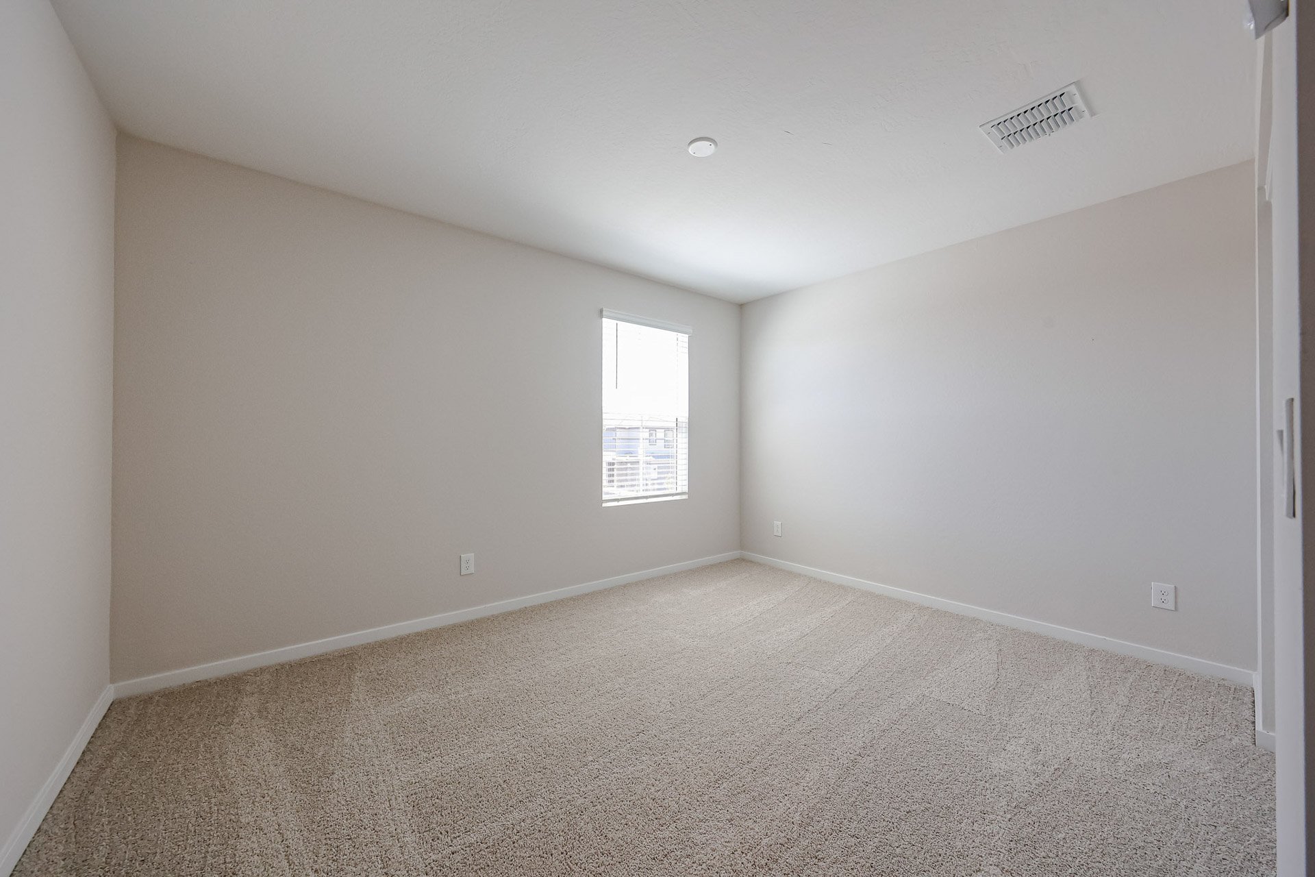 A room with a carpet and a window.