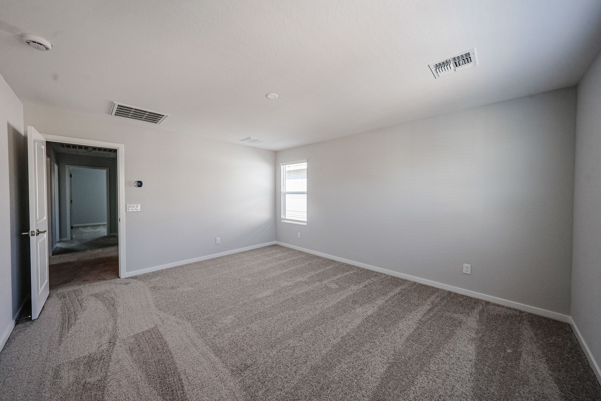 A room with a carpet and a door.