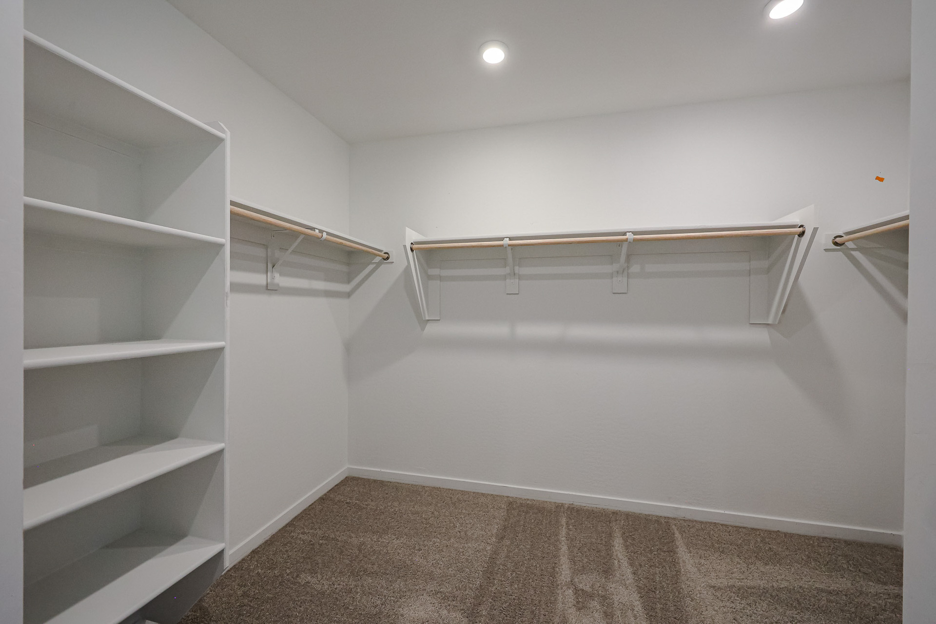 A white room with shelves.