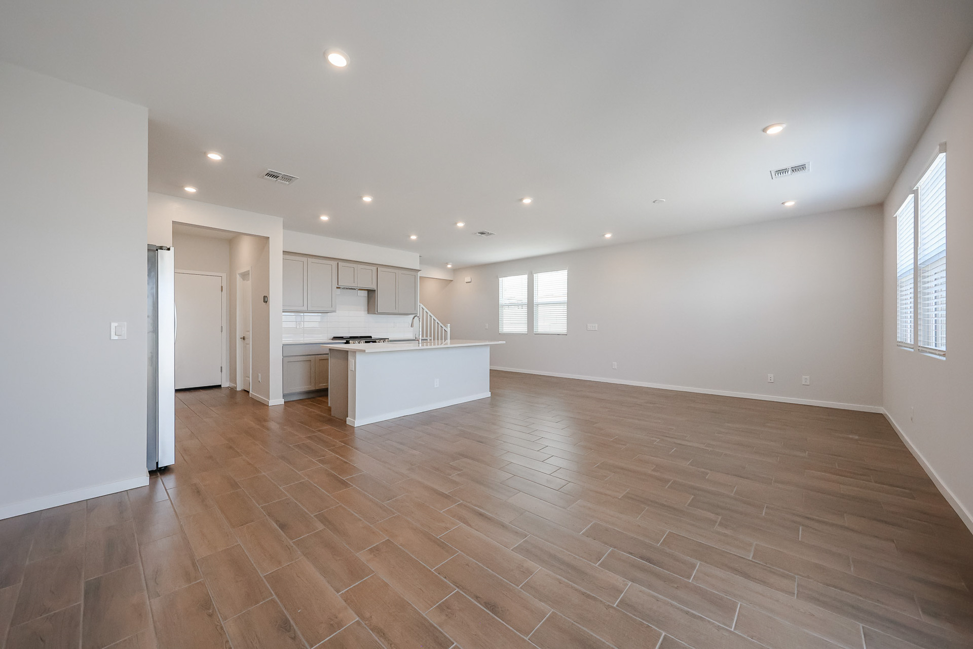 A large empty room with a wood floor and white walls.