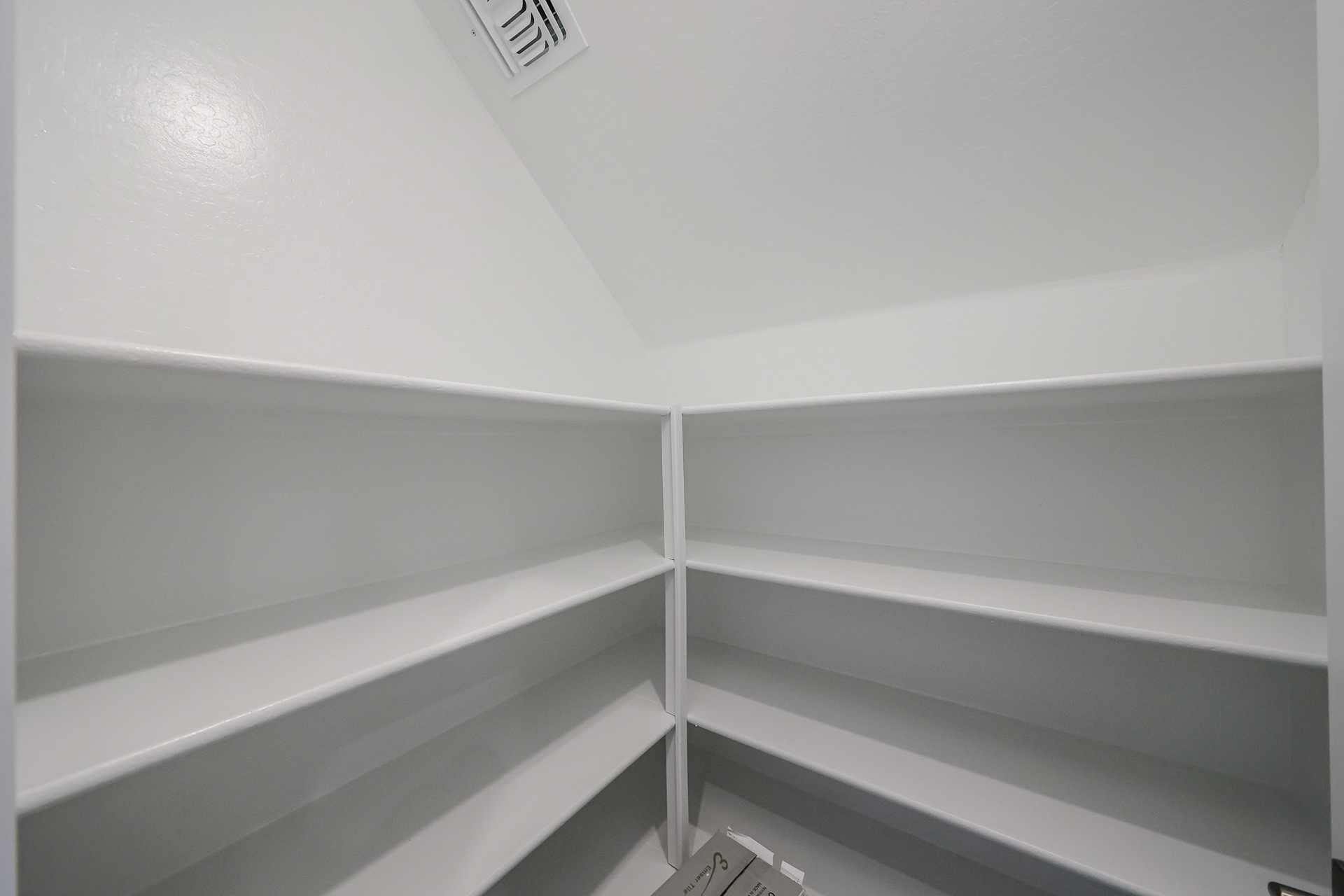 A white shelf with a white wall.
