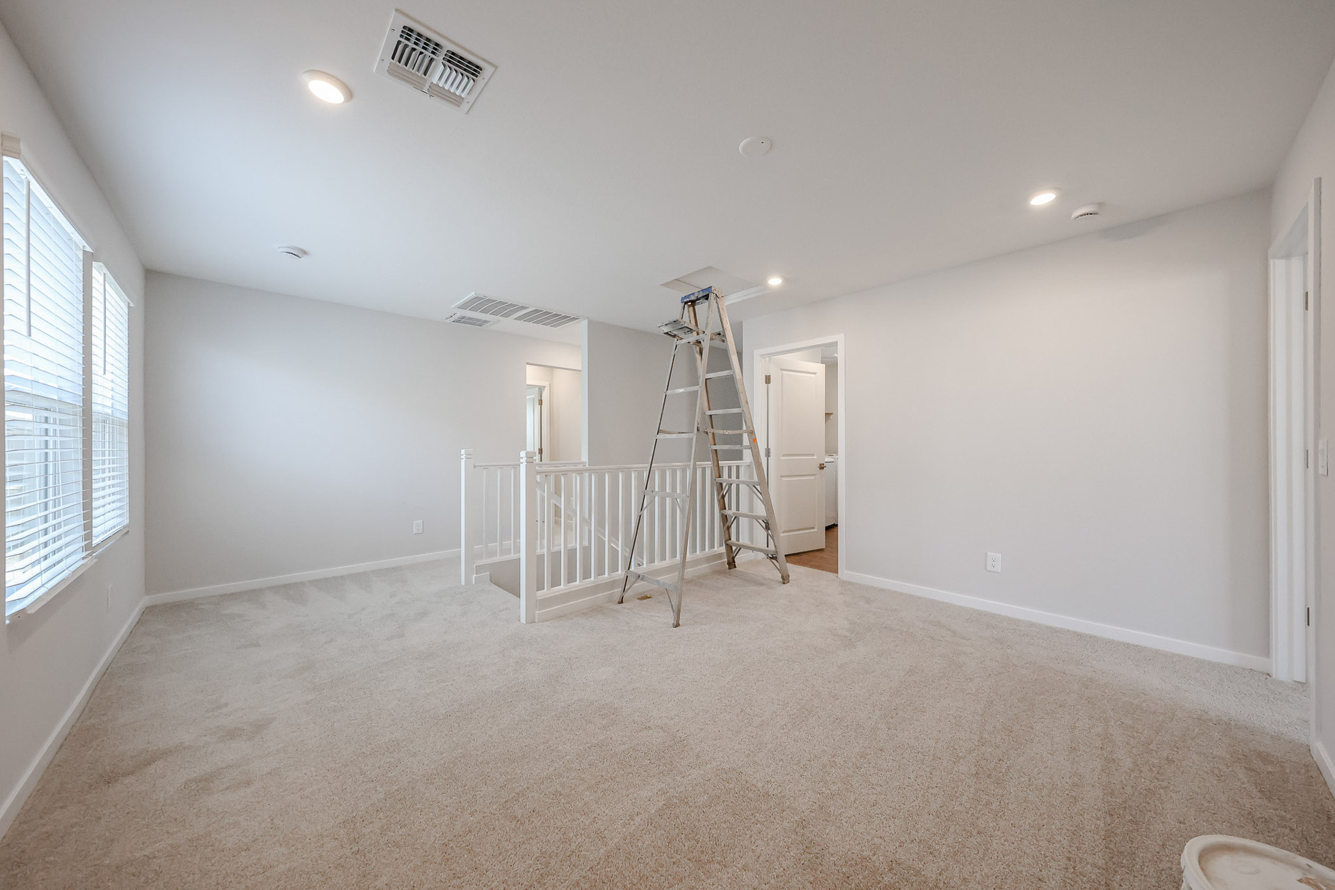 A room with a ladder and a door.