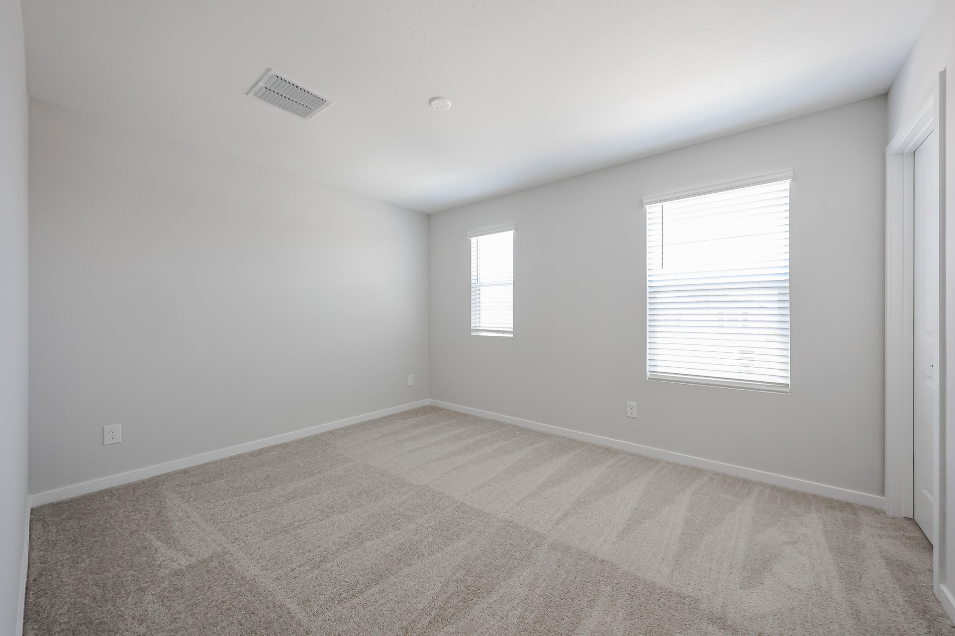 A room with a carpet and windows.