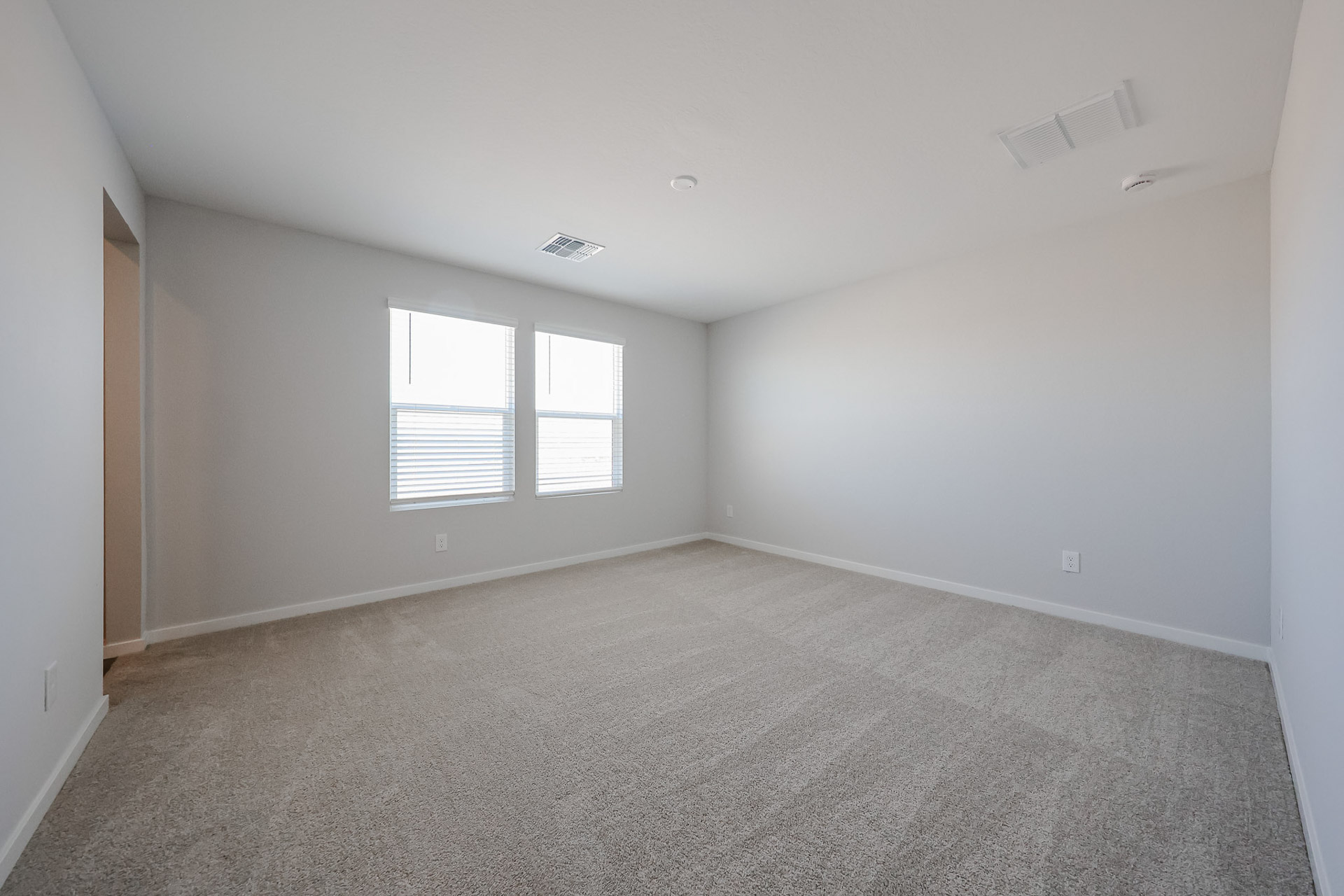 A room with a carpet and windows.