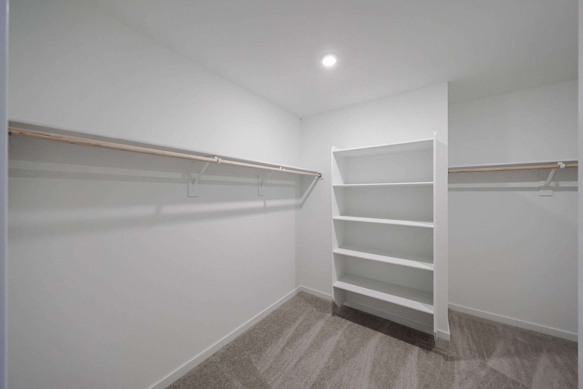 A white wall with a white shelf.