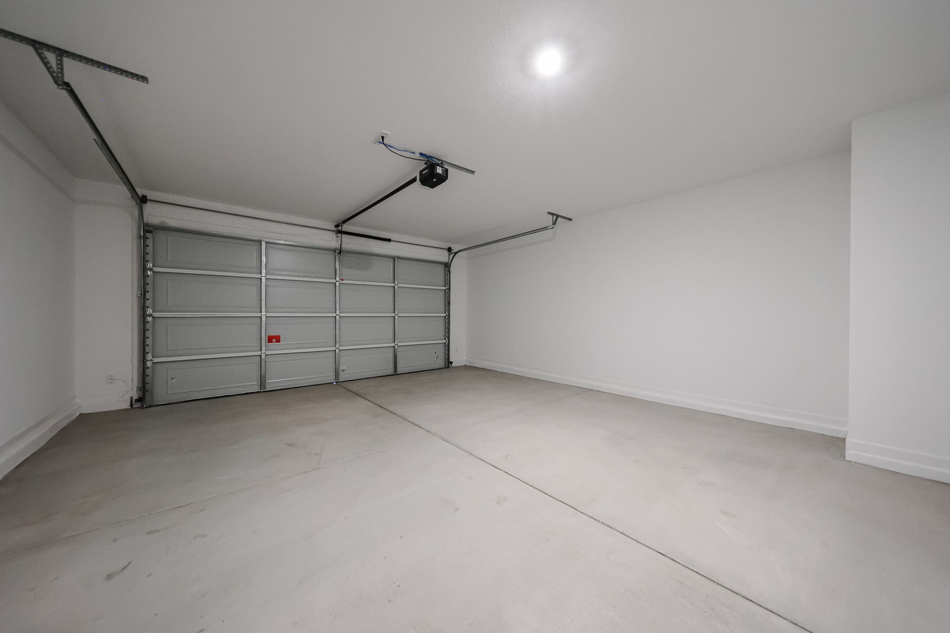 A room with a metal door and a light on the ceiling.