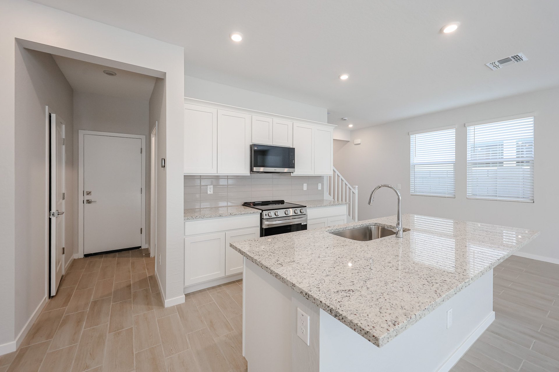 A kitchen with white cabinets.