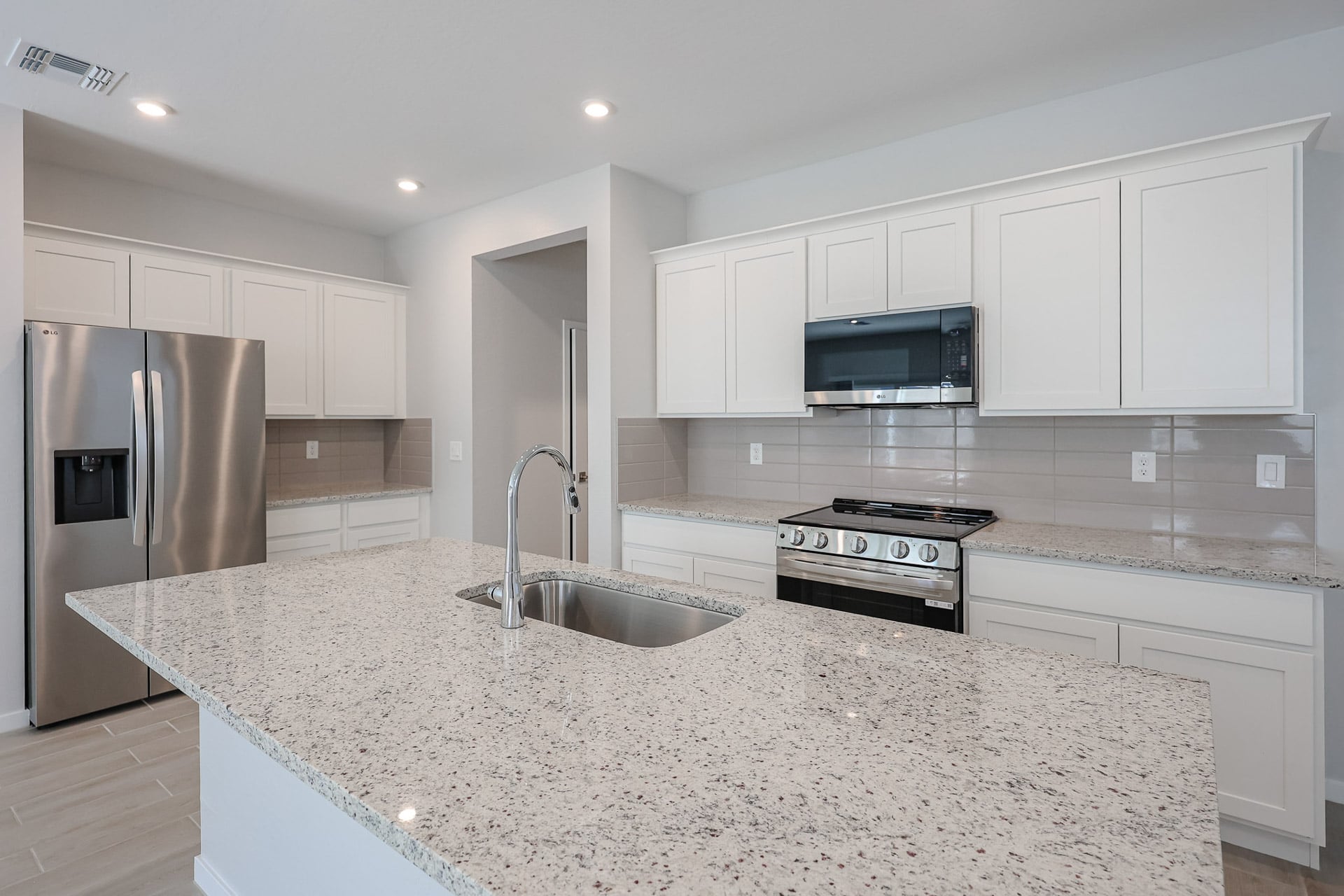 A kitchen with white cabinets.