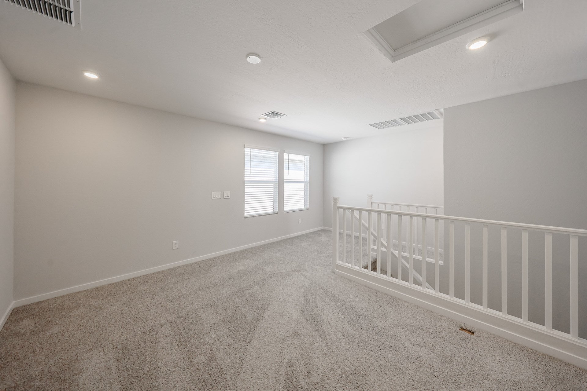 A room with a white railing and a white railing.
