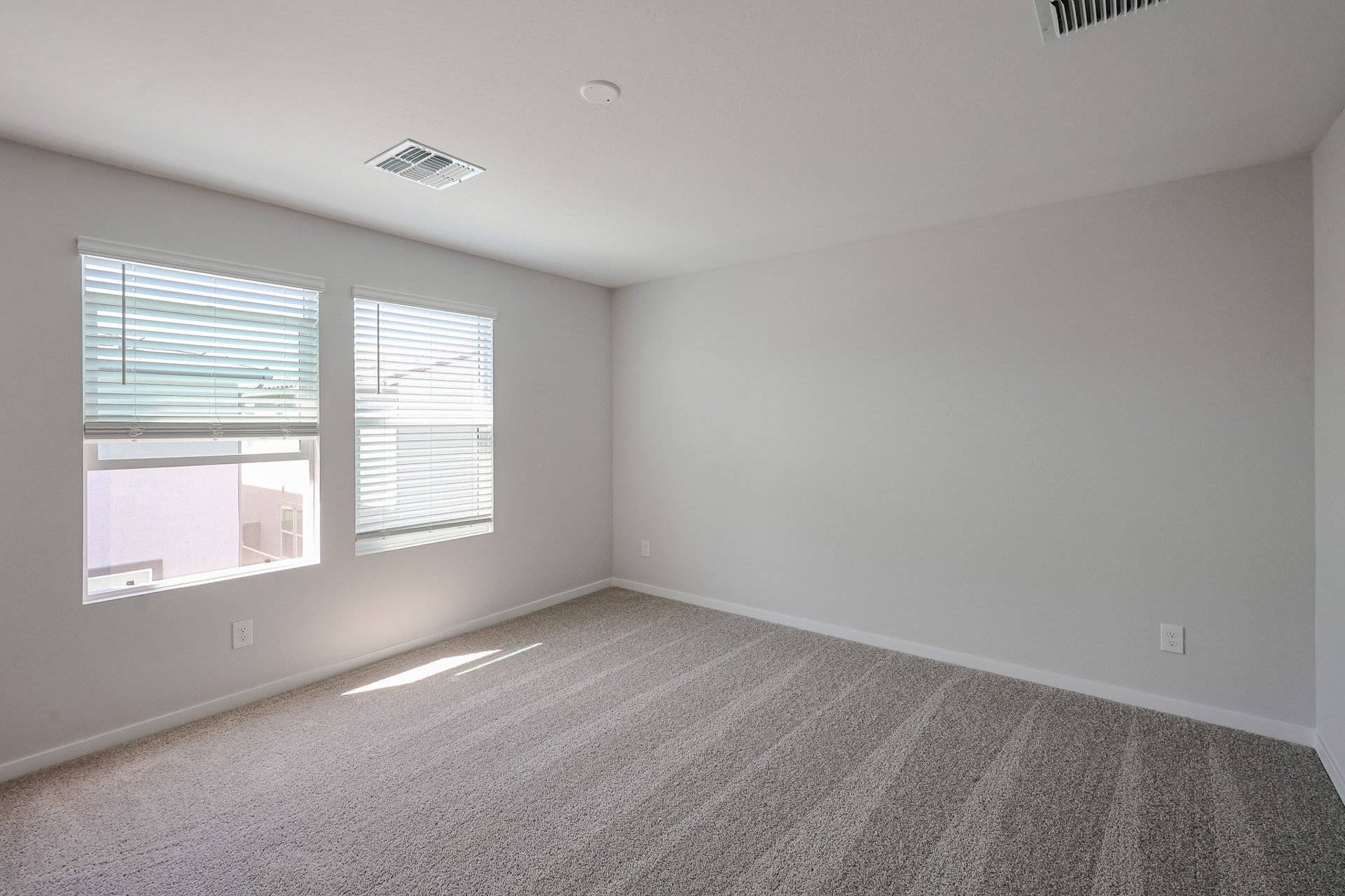 A room with a carpet and windows.