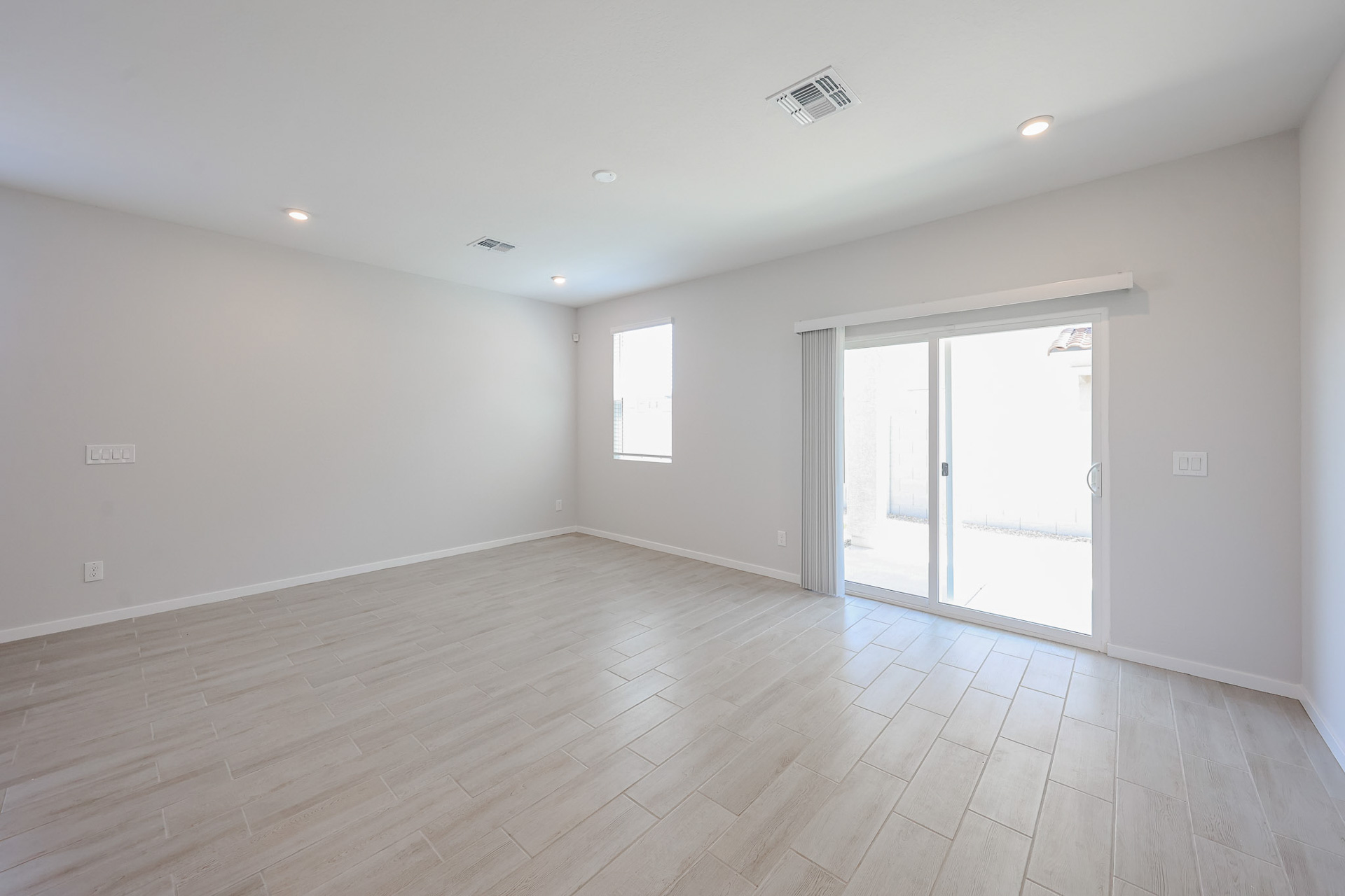 A room with a wood floor and a glass door.