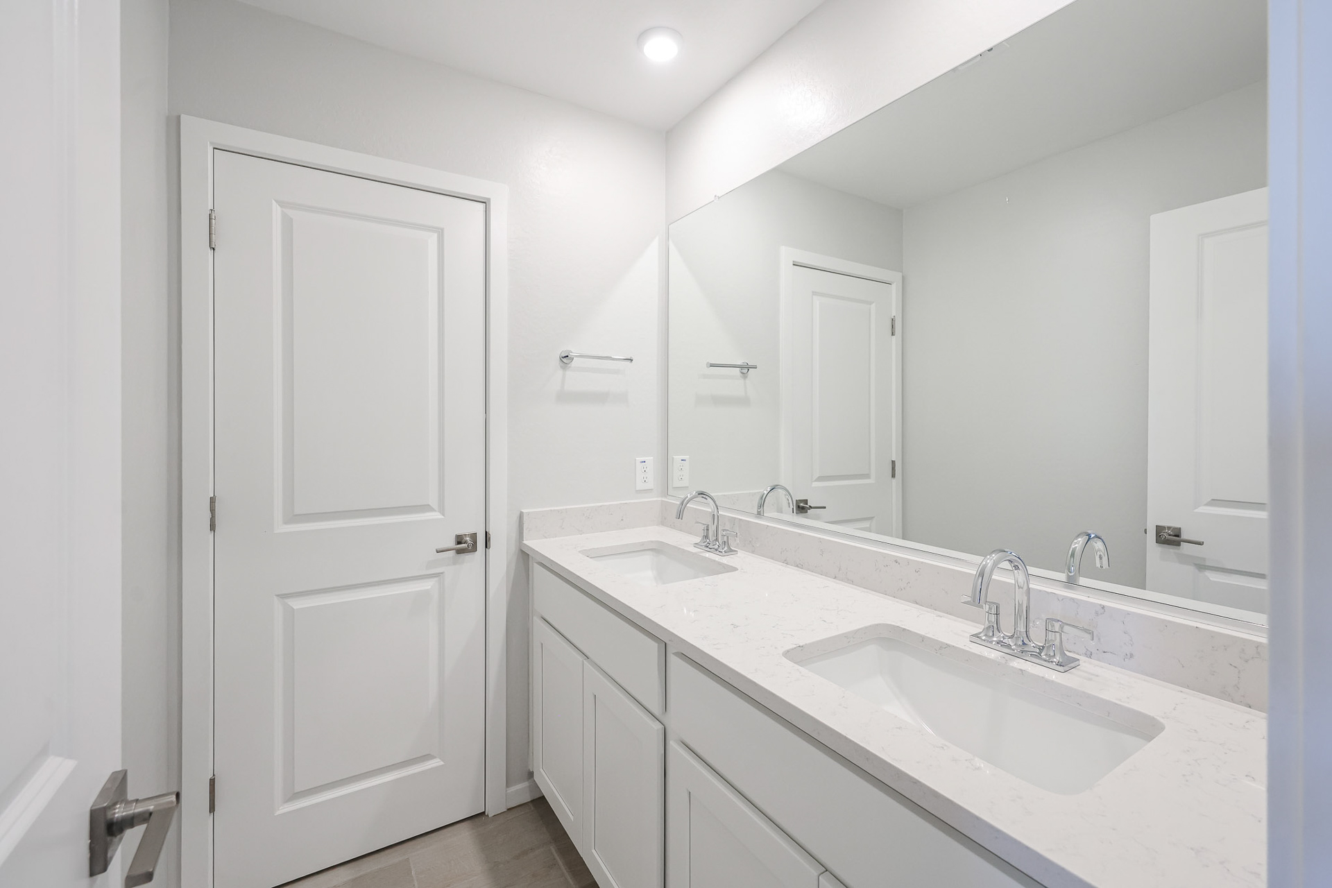 A bathroom with white cabinets.
