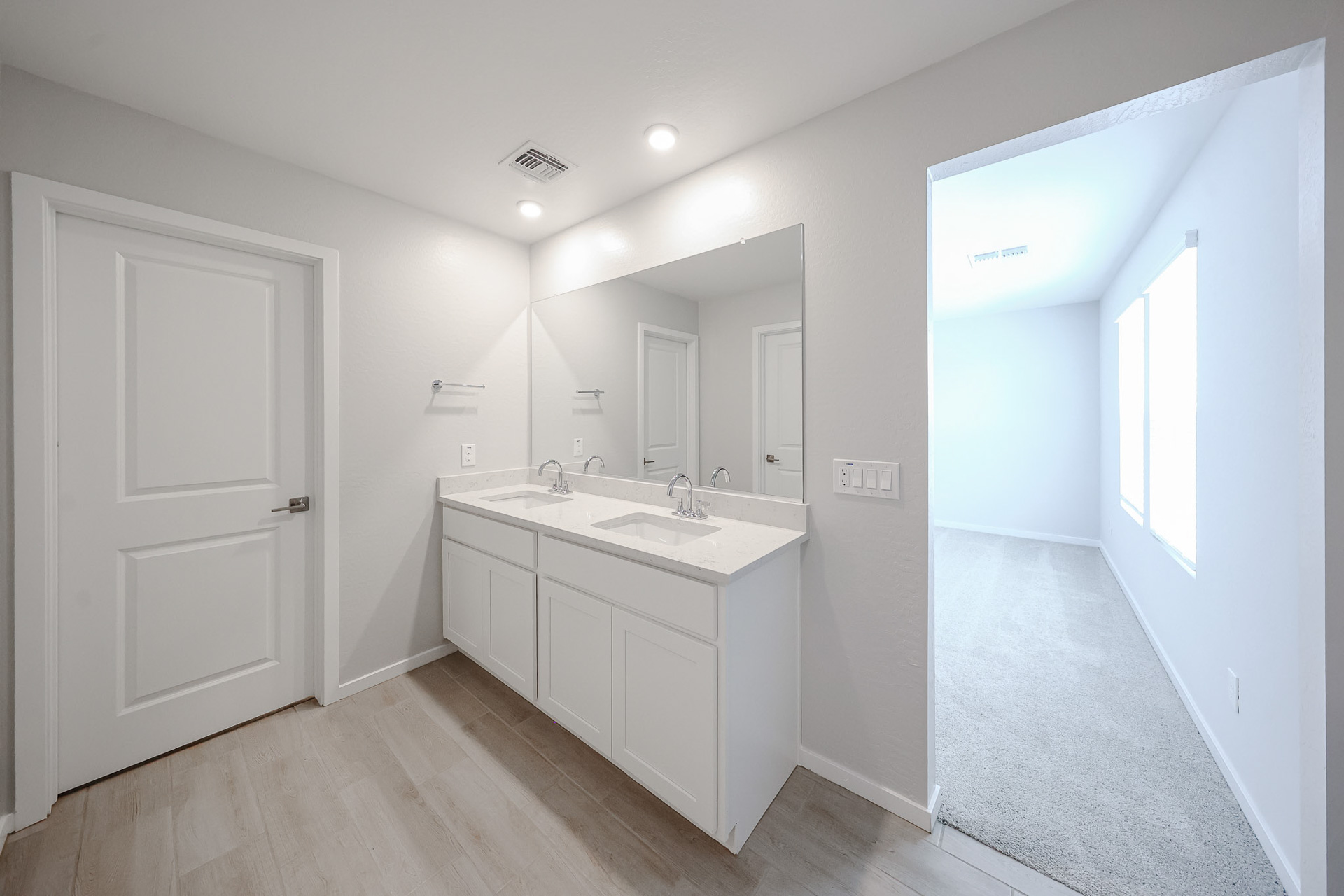 A bathroom with white cabinets.